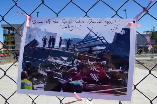 A tribute left on the cordon fence around the CTV Building site. The card shows a photograph of rescuers working on the CTV site, and reads, "Some of the guys who found you!! Thank you!"