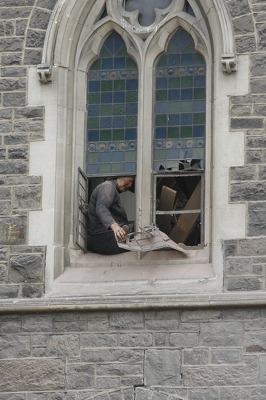 Sue Spigel seated in the window of the partially collapsed cathedral