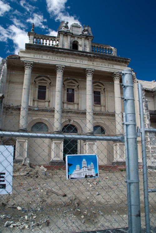 Basilica, post-quake, front view, seen through fence