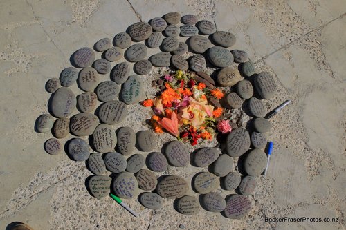 Messages are written on stones and laid in a circle with flowers at the CTV building site on the anniversary of the 22 February 2011 earthquake.